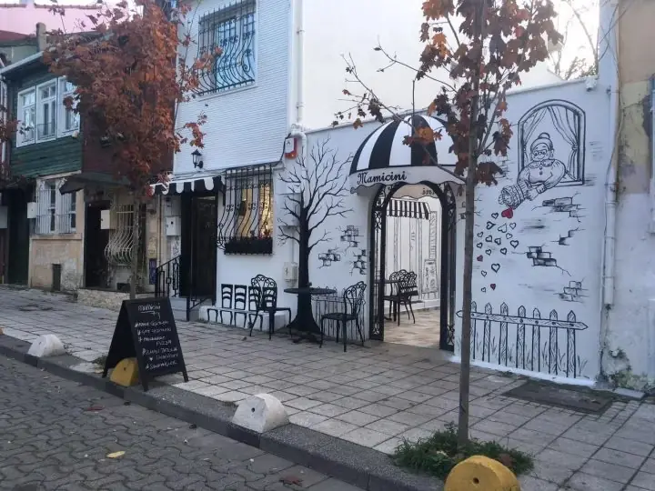 Cephesi el çizimi illüstrasyonlarla kaplı bina girişi